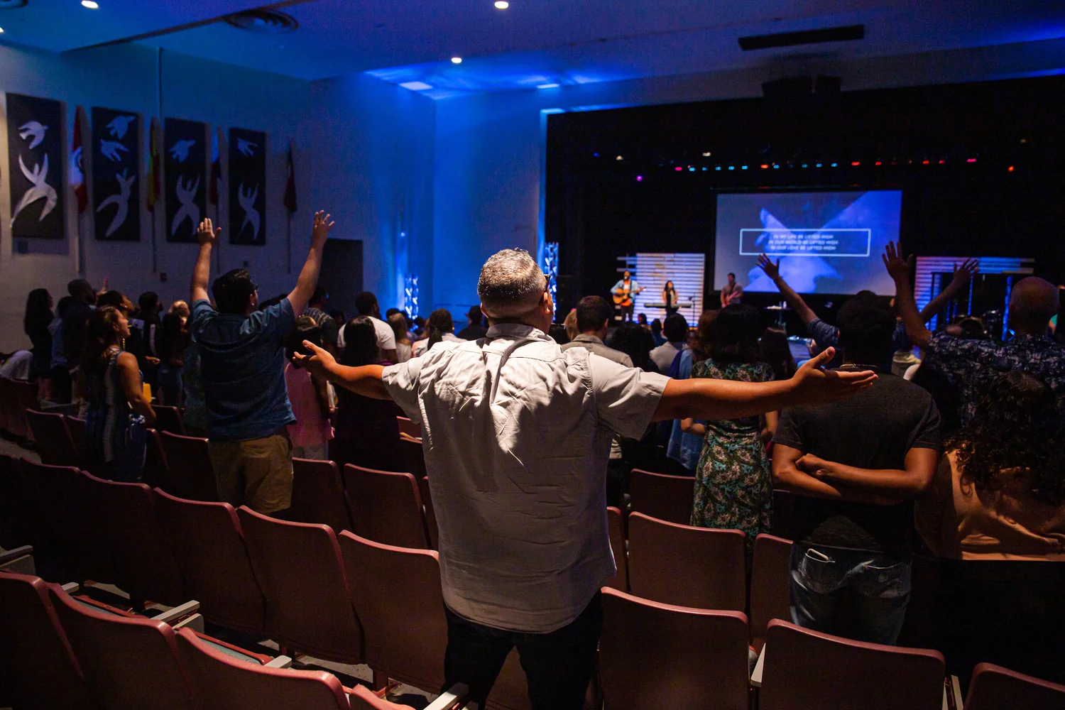 A congregation worshiping together with hands raised